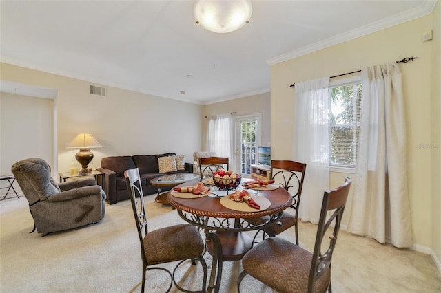 carpeted dining area featuring a wealth of natural light and ornamental molding