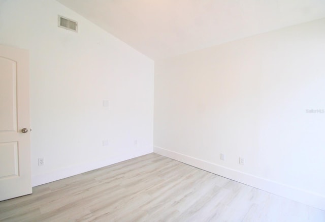 empty room featuring light hardwood / wood-style floors and lofted ceiling