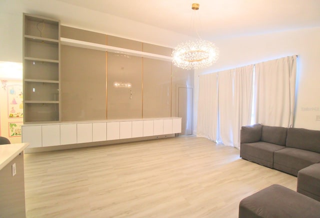 unfurnished living room with light wood-type flooring and an inviting chandelier