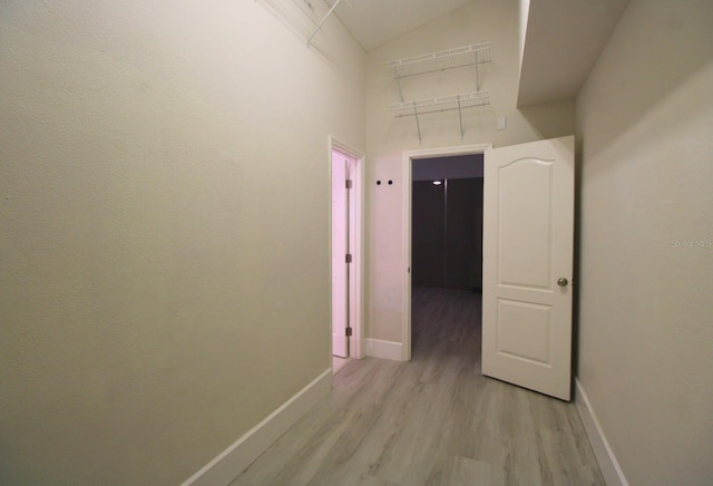 hall with light hardwood / wood-style floors and a high ceiling