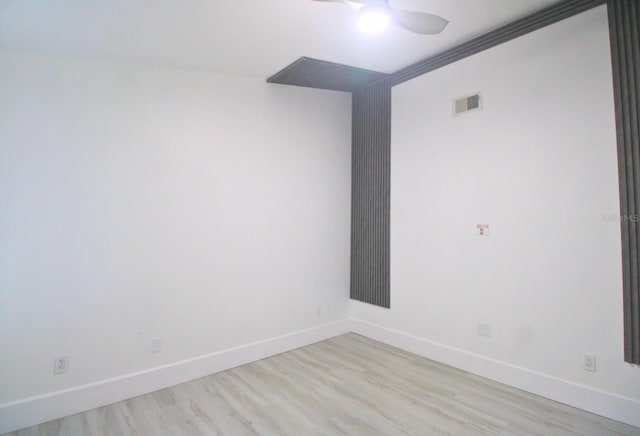 empty room with ceiling fan, ornamental molding, and light wood-type flooring