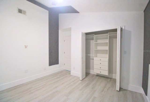 unfurnished bedroom featuring a closet and light wood-type flooring