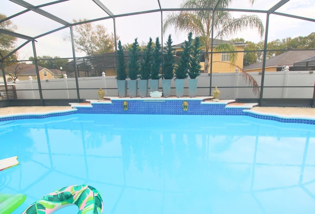 view of swimming pool featuring a lanai, a fenced in pool, and fence