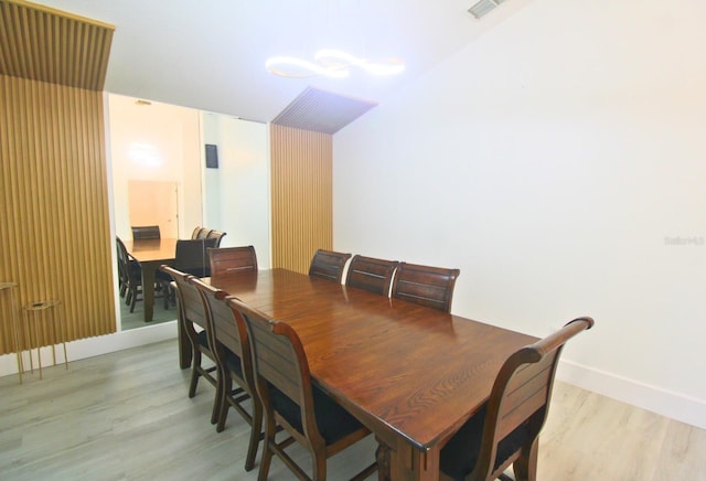 dining room featuring visible vents, light wood-style flooring, and baseboards