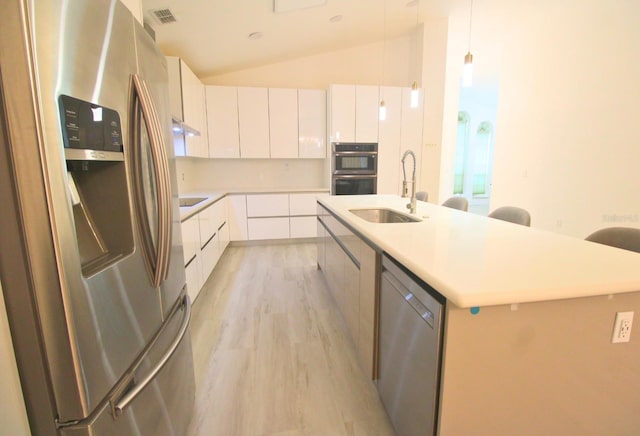 kitchen featuring white cabinets, appliances with stainless steel finishes, sink, and an island with sink