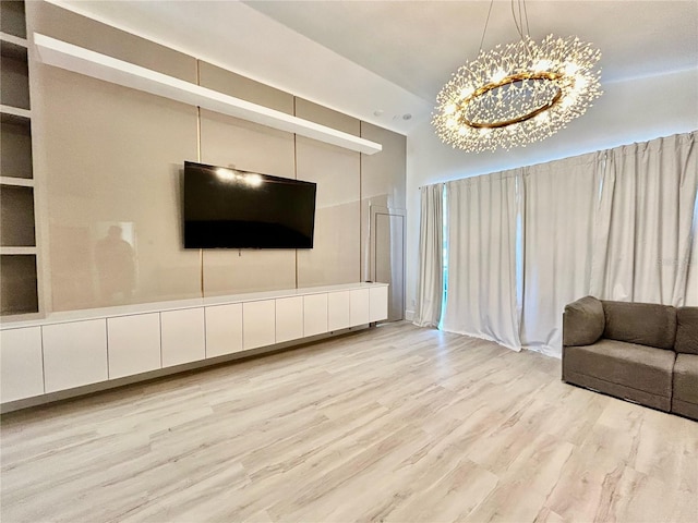 unfurnished living room featuring a notable chandelier and light wood-style floors