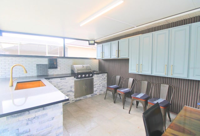 kitchen featuring light countertops, a sink, and blue cabinets