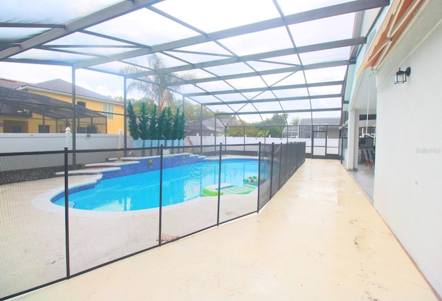 view of swimming pool featuring a fenced in pool, glass enclosure, and a fenced backyard