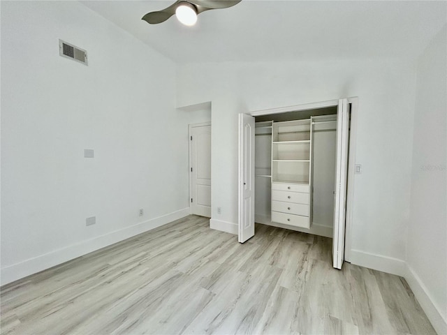 unfurnished bedroom featuring light wood-style flooring, a ceiling fan, visible vents, vaulted ceiling, and baseboards