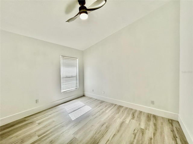 unfurnished room with baseboards, vaulted ceiling, a ceiling fan, and light wood-style floors