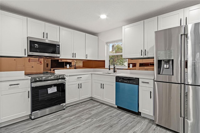 kitchen with sink, white cabinetry, stainless steel appliances, and a textured ceiling