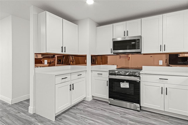 kitchen with white cabinetry, light hardwood / wood-style flooring, and stainless steel appliances