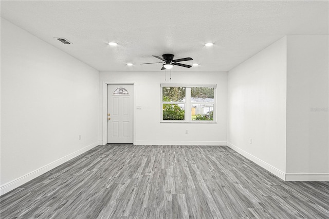 spare room with a textured ceiling, ceiling fan, and hardwood / wood-style floors