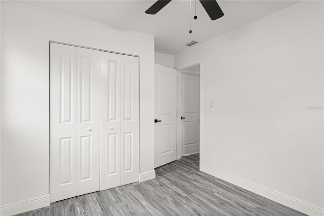 unfurnished bedroom featuring ceiling fan, a closet, and light hardwood / wood-style floors