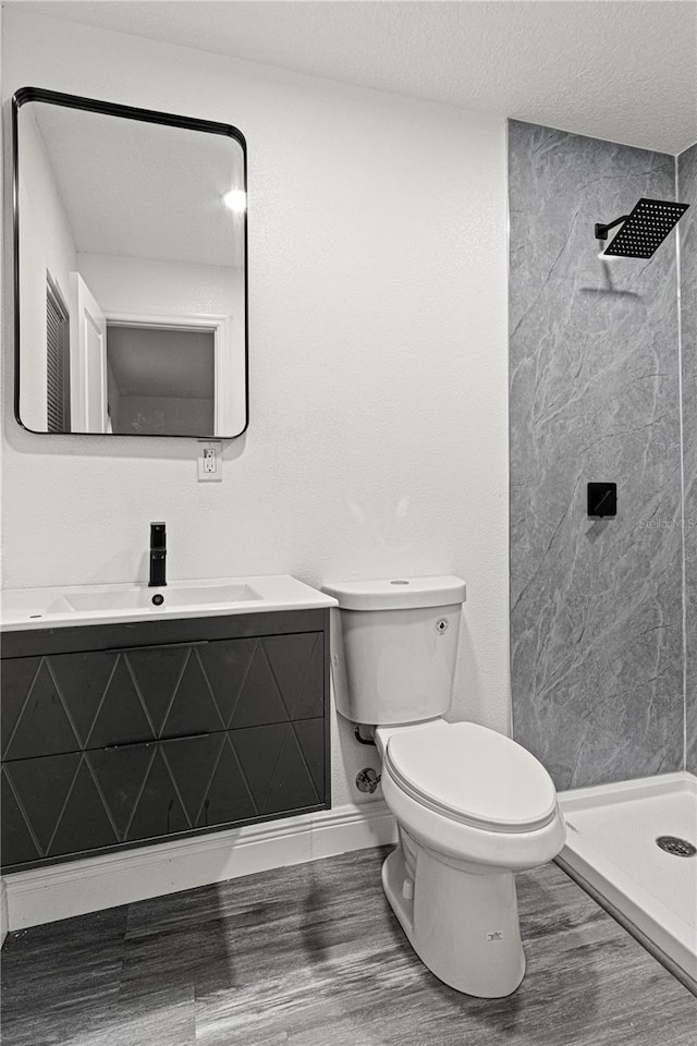 bathroom featuring a shower, a textured ceiling, toilet, and vanity