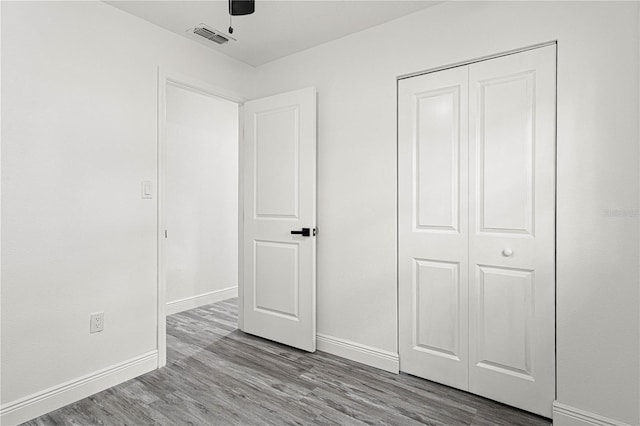 unfurnished bedroom featuring ceiling fan, a closet, and light hardwood / wood-style flooring