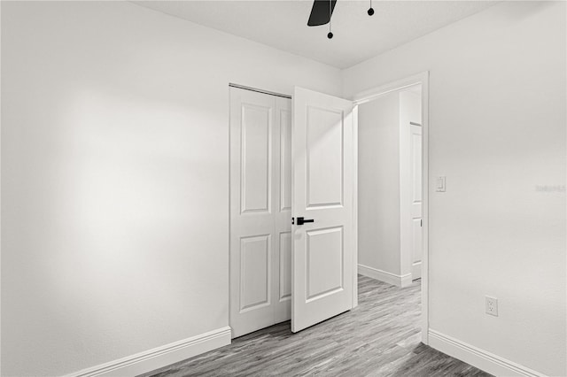 unfurnished bedroom with ceiling fan, a closet, and light hardwood / wood-style floors