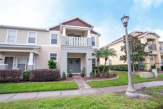 view of front facade featuring a balcony and a front lawn