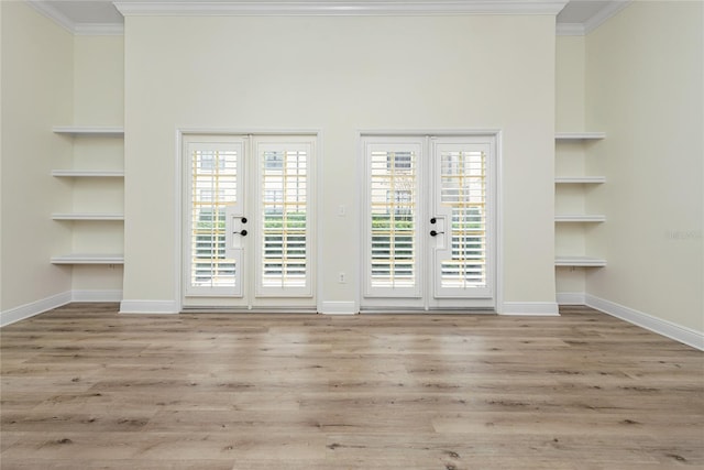 spare room featuring built in shelves, ornamental molding, and french doors