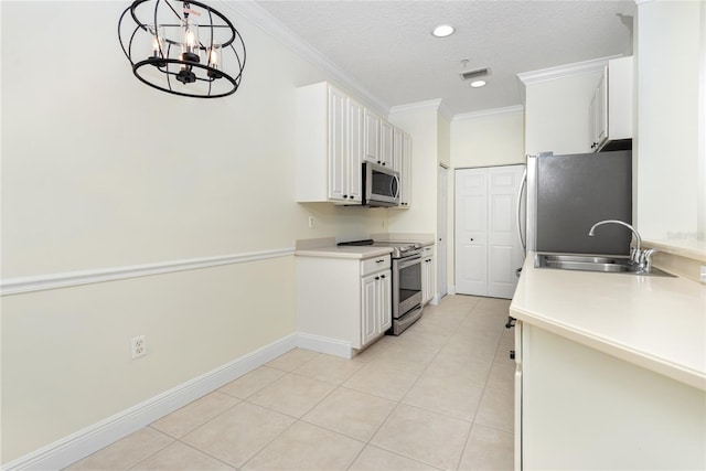 kitchen featuring pendant lighting, sink, white cabinets, ornamental molding, and stainless steel appliances