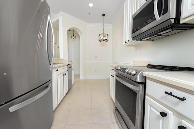 kitchen with pendant lighting, white cabinetry, ornamental molding, and appliances with stainless steel finishes