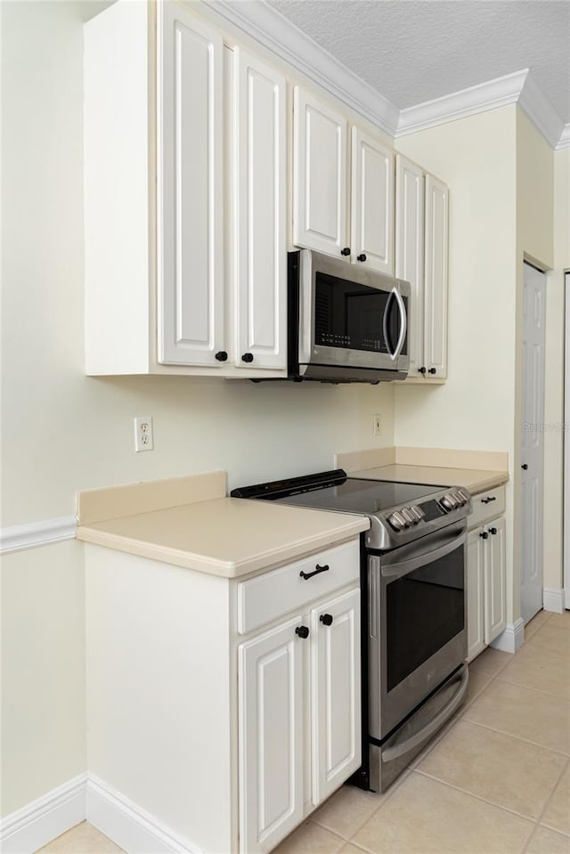 kitchen with white cabinets, light tile patterned floors, and appliances with stainless steel finishes