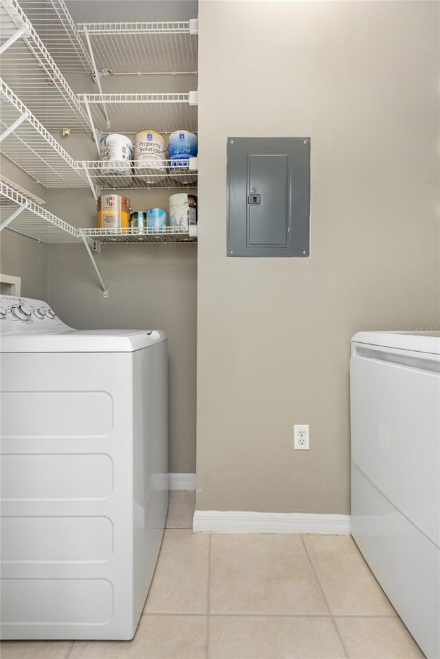 washroom featuring electric panel, light tile patterned floors, and washer and dryer