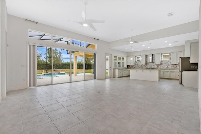 unfurnished living room featuring ceiling fan and light tile patterned floors