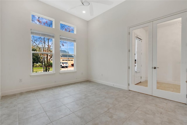 spare room featuring light tile patterned flooring, ceiling fan, and french doors