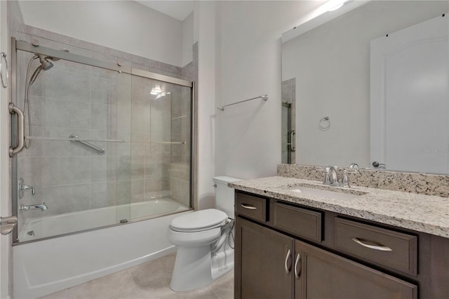 full bathroom with tile patterned floors, bath / shower combo with glass door, toilet, and vanity