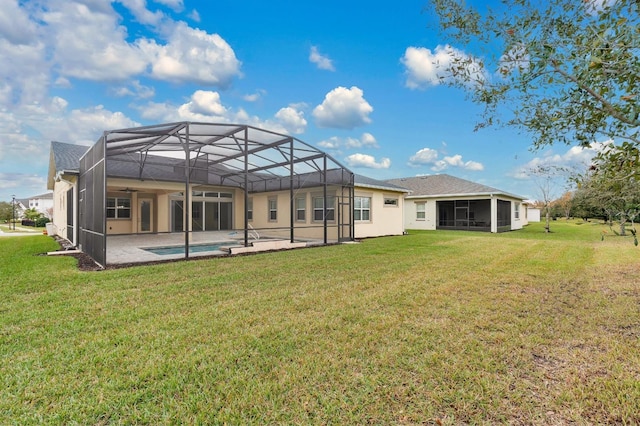 rear view of house featuring a sunroom, a patio area, and a lawn