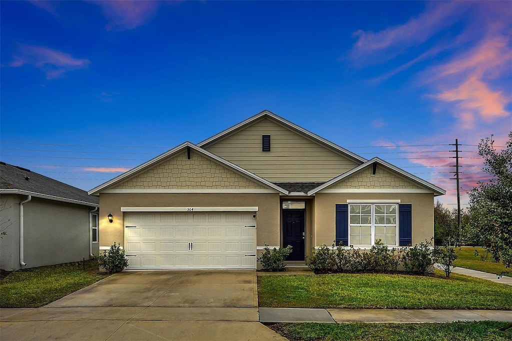 view of front of home featuring a garage and a lawn