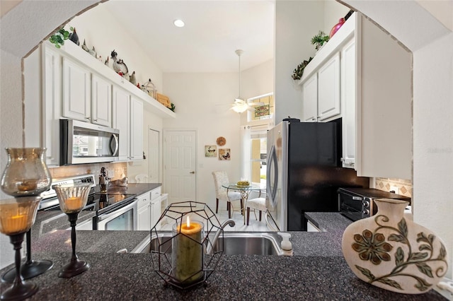 kitchen with ceiling fan, appliances with stainless steel finishes, white cabinetry, tasteful backsplash, and kitchen peninsula