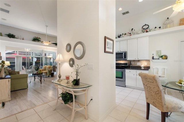 kitchen featuring light tile patterned flooring, ceiling fan, and appliances with stainless steel finishes