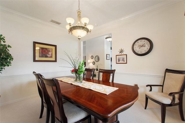 carpeted dining room featuring an inviting chandelier and ornamental molding