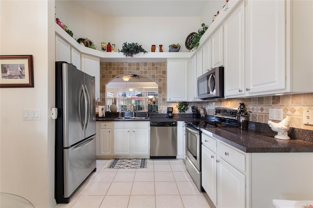 kitchen featuring sink, light tile patterned flooring, white cabinets, and appliances with stainless steel finishes