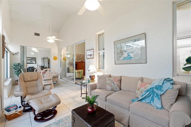 tiled living room with high vaulted ceiling and ceiling fan