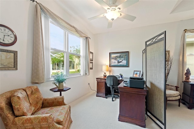 carpeted home office featuring ceiling fan