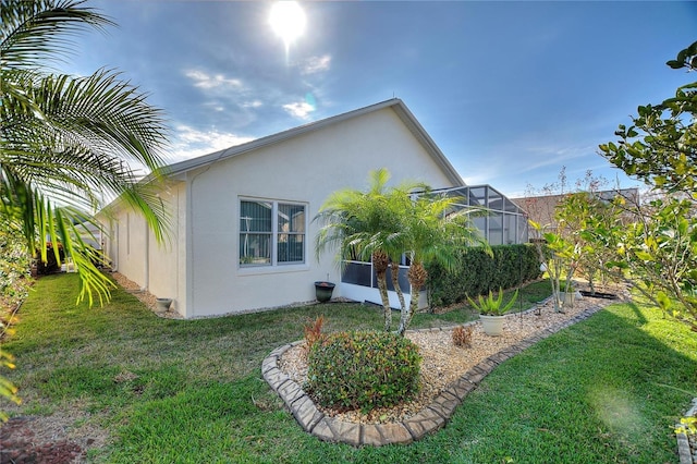 rear view of property with a yard and glass enclosure