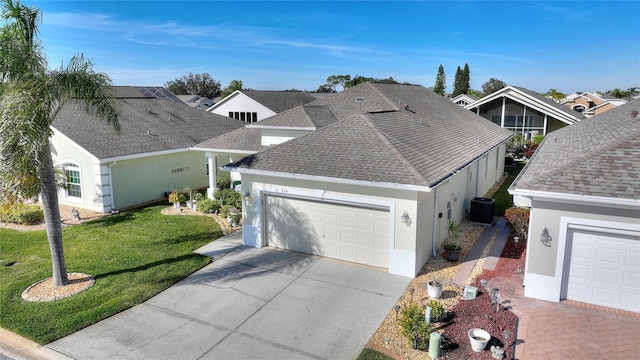 view of front of house featuring a garage, central air condition unit, and a front lawn