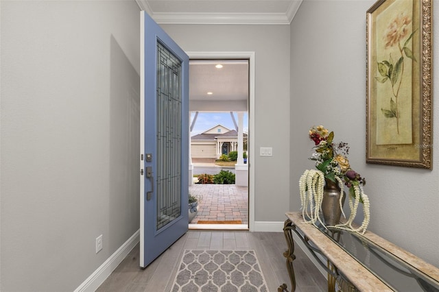 foyer entrance with crown molding and hardwood / wood-style floors