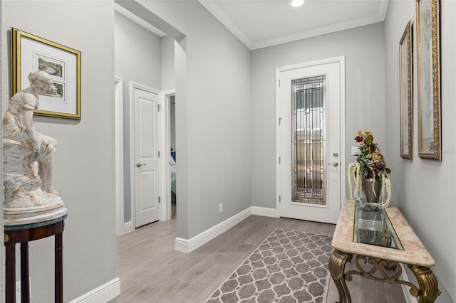 doorway to outside with ornamental molding and light hardwood / wood-style floors