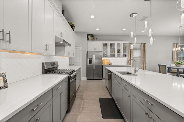 kitchen with pendant lighting, sink, gray cabinetry, stainless steel appliances, and white cabinets