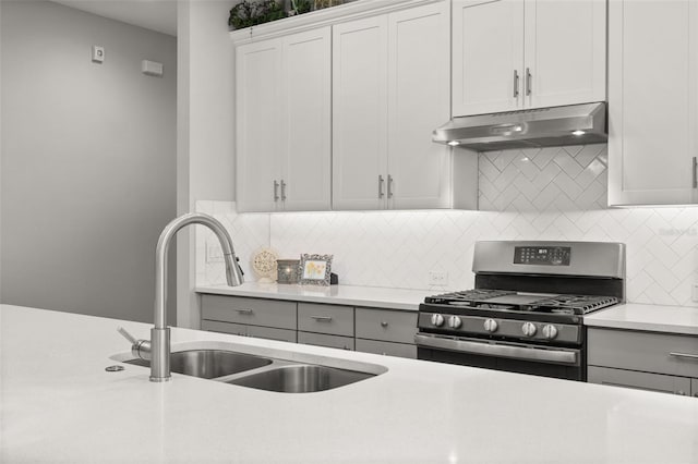 kitchen featuring white cabinetry, sink, backsplash, and gas stove