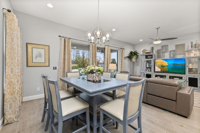 dining area with ceiling fan with notable chandelier and light wood-type flooring