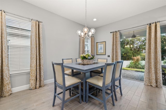 dining area with light hardwood / wood-style floors and a chandelier