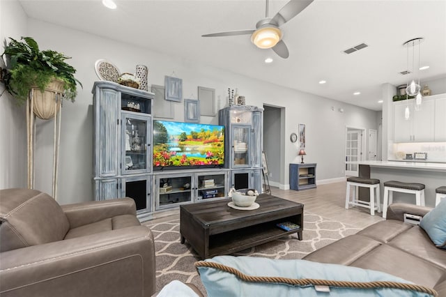 living room with ceiling fan and light hardwood / wood-style floors