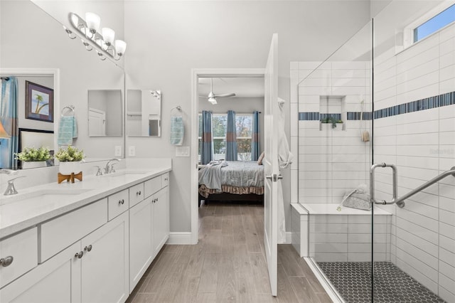 bathroom featuring wood-type flooring, vanity, ceiling fan, and a shower with shower door