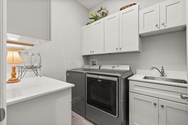 laundry area featuring sink, cabinets, and washing machine and clothes dryer