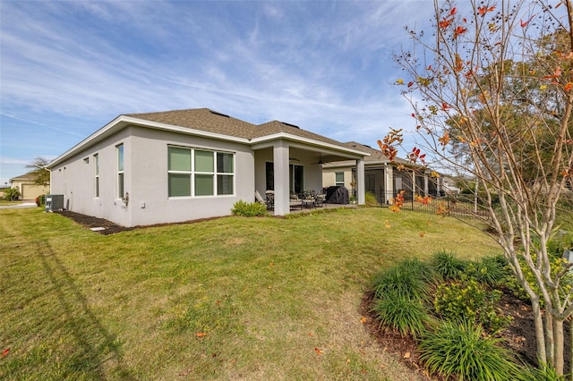 rear view of house featuring central AC, a patio area, and a lawn